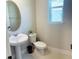 Elegant powder room with pedestal sink, oval mirror, and modern fixtures at 16337 Silver Grove Blvd, Winter Garden, FL 34787
