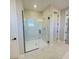 Large walk-in shower with marble tile and frameless glass door at 16337 Silver Grove Blvd, Winter Garden, FL 34787