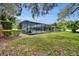 Expansive backyard with a screened pool, mature trees, and well-manicured landscaping offers a private oasis at 1901 Lake Sue Dr, Orlando, FL 32803