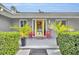 Inviting entrance featuring a bright yellow door flanked by potted plants and chairs at 1901 Lake Sue Dr, Orlando, FL 32803