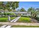 Lovely one-story home featuring lush landscaping, a striking yellow door, and a stylish pathway to the entrance at 1901 Lake Sue Dr, Orlando, FL 32803