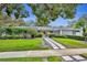 Inviting one-story home with lush landscaping, vibrant yellow door, and paver walkway to the entrance at 1901 Lake Sue Dr, Orlando, FL 32803