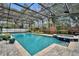 A large, screened-in pool and hot tub is surrounded by a brick paver deck and lush greenery at 1901 Lake Sue Dr, Orlando, FL 32803