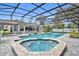 An in-ground pool with attached spa surrounded by pavers, covered by a screen enclosure, offering a backyard oasis at 1901 Lake Sue Dr, Orlando, FL 32803