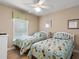 Two twin beds in a well-lit bedroom with patterned bedding at 2119 Victoria Dr, Davenport, FL 33837