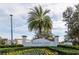 The Enclaves at Festival community entrance, featuring a landscaped area with flowering plants and palm trees at 236 Captiva Dr, Davenport, FL 33896