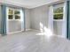 A cozy bedroom with light gray walls, white trim, and a window dressed with white and teal curtains at 2901 Primrose Ct, Orlando, FL 32803