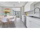 Bright kitchen featuring white cabinets, stainless steel appliances and view to living area at 2901 Primrose Ct, Orlando, FL 32803