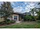 Landscaped backyard with screened patio and lush greenery at 38633 Lakeview Walk, Lady Lake, FL 32159