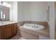 Bathroom with bathtub and wooden cabinets at 38633 Lakeview Walk, Lady Lake, FL 32159