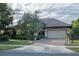 Two-story house with a three car garage and manicured lawn at 38633 Lakeview Walk, Lady Lake, FL 32159