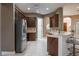 Spacious kitchen features dark wood cabinets, stainless steel appliances, and a breakfast bar at 38633 Lakeview Walk, Lady Lake, FL 32159