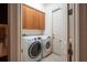 Bright laundry room, washer, dryer, cabinets, and built-in storage at 38633 Lakeview Walk, Lady Lake, FL 32159