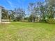 Large grassy backyard with mature trees and a satellite dish at 604 Elfrida Way, Kissimmee, FL 34758