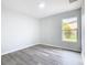 Well-lit bedroom featuring new flooring and a window with backyard view at 604 Elfrida Way, Kissimmee, FL 34758