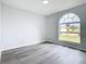 Spacious bedroom with an arched window and wood-look floors at 604 Elfrida Way, Kissimmee, FL 34758