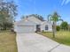 Gray house with a two-car garage and a palm tree at 604 Elfrida Way, Kissimmee, FL 34758