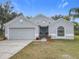 Gray house with a two-car garage and landscaped yard at 604 Elfrida Way, Kissimmee, FL 34758