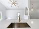 Modern kitchen island with a farmhouse sink and a gold faucet at 604 Elfrida Way, Kissimmee, FL 34758