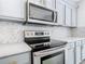 Modern kitchen with stainless steel appliances and gray cabinets at 604 Elfrida Way, Kissimmee, FL 34758