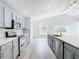 Open concept kitchen with gray cabinets, quartz countertops, and stainless steel appliances at 604 Elfrida Way, Kissimmee, FL 34758