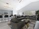 Open living room and kitchen with vaulted ceilings, modern lighting, and stylish furnishings at 604 Elfrida Way, Kissimmee, FL 34758