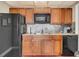 Community kitchen featuring wood cabinets and black appliances at 690 Osceola Ave # 209, Winter Park, FL 32789