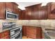 Well-equipped kitchen featuring stainless steel appliances and wood cabinets at 690 Osceola Ave # 209, Winter Park, FL 32789