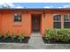 Inviting exterior with a light orange facade, landscaping, and a walkway at 734 E Michigan St # 113, Orlando, FL 32806