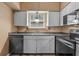 Updated kitchen with gray cabinets and black appliances at 734 E Michigan St # 113, Orlando, FL 32806
