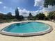 Exterior shot of neighborhood pool features shallow end with seating and landscaping around the perimeter at 734 E Michigan St # 113, Orlando, FL 32806