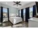 Bedroom with white bed frame, blue curtains, and wood-look tile floors at 8137 Surf St, Kissimmee, FL 34747