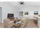 Bright living room with beige furniture, wood-look floors, and a large TV at 878 Galloway St, Lake Alfred, FL 33850