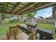 Backyard patio with a grilling station and a wooden chair under a covered structure at 8836 Ava Lake Dr, Orlando, FL 32810