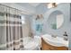 Bright bathroom with a vanity, mirror, tub with shower, and decorative curtain at 8836 Ava Lake Dr, Orlando, FL 32810