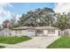 Charming single-story home with stone accents, a well-manicured lawn, and mature trees, offering curb appeal at 8836 Ava Lake Dr, Orlando, FL 32810