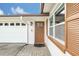 Close-up of the front entrance with a stylish door, brick walkway, and white garage door with windows at 8836 Ava Lake Dr, Orlando, FL 32810