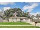Inviting single-story home with a lush green lawn and a paved driveway leading up to the house at 8836 Ava Lake Dr, Orlando, FL 32810