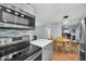 Eat-in kitchen featuring stainless steel appliances, pendant lighting, and a view of the open-concept dining area at 8836 Ava Lake Dr, Orlando, FL 32810