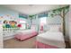 Bedroom with two twin beds, fun wall art, and pink accents at 9009 Rhodes St, Kissimmee, FL 34747