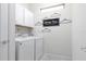 Laundry room with washer, dryer, and overhead cabinets at 9009 Rhodes St, Kissimmee, FL 34747