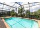 Screened pool and spa with brick coping and landscaping at 9009 Rhodes St, Kissimmee, FL 34747