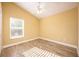 Sunny bedroom with wood-look floors and ceiling fan at 10050 Hidden Dunes Ln, Orlando, FL 32832