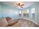 Living room with light walls, wood-look floors and large windows at 10050 Hidden Dunes Ln, Orlando, FL 32832