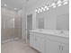 Bright bathroom featuring a double vanity with white cabinets and a glass-enclosed shower at 1123 Happy Forest Loop, Deland, FL 32720