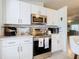 White kitchen cabinets, stainless steel appliances, and quartz countertops at 120 Crooked Pine Rd, Port Orange, FL 32128