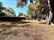 Spacious backyard with large trees and a wood pile at 12151 Se 86Th Ave, Belleview, FL 34420