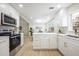 Open concept kitchen boasting white cabinets, quartz countertops and stainless steel appliances at 1266 Sandestin Way, Orlando, FL 32824