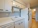 White kitchen with stainless steel dishwasher and view into living area at 127 Springwood Cir # A, Longwood, FL 32750
