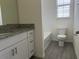 Clean bathroom with granite countertop, white cabinets, and a bathtub at 16704 Point Rock Dr, Winter Garden, FL 34787